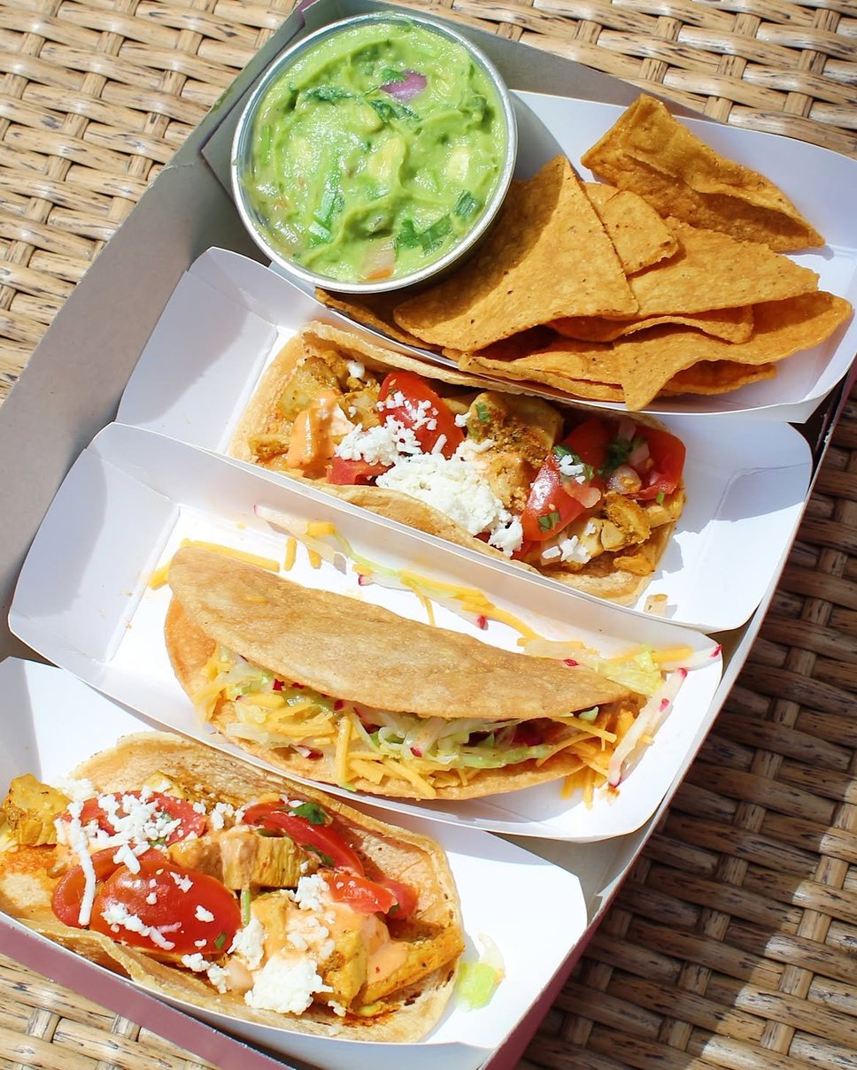 Guacamole and chips alongside chicken and beer-battered fish tacos · 📸 PHOTO VIA @CHICASTACOS