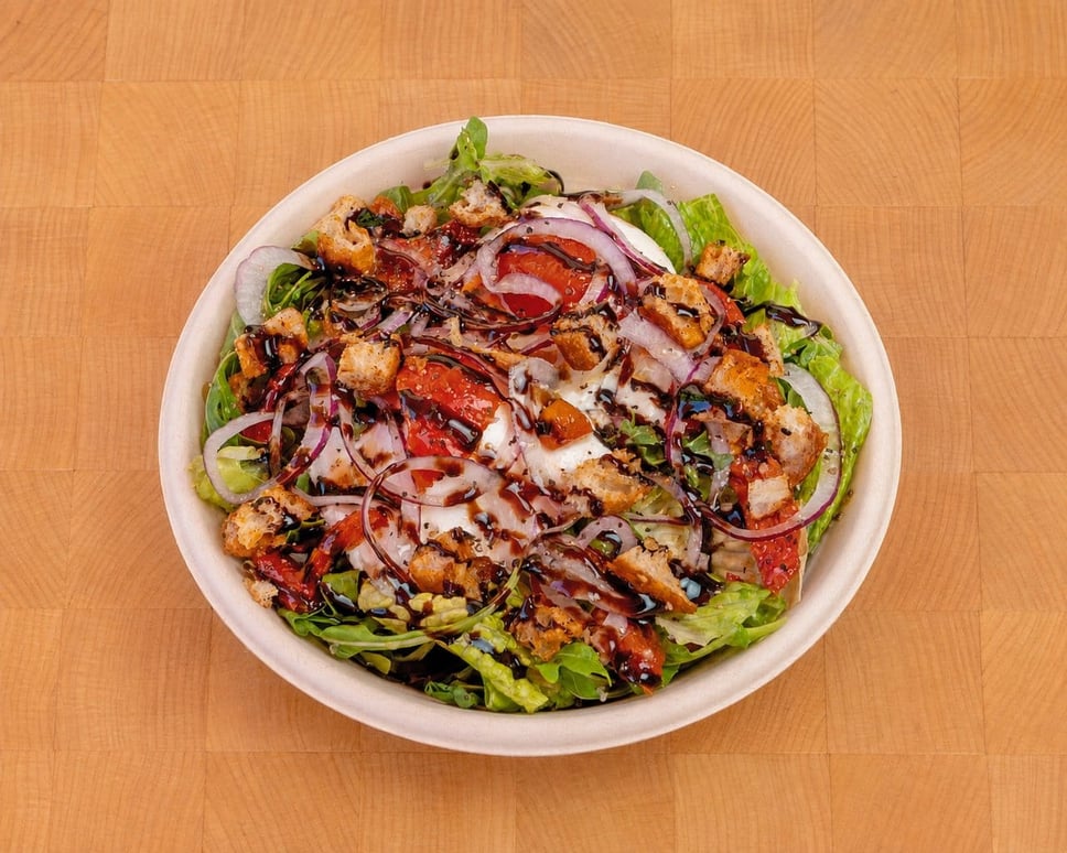 The Dima salad: arugula, burrata, roasted tomatoes, balsamic glaze and focaccia croutons · 📸 PHOTO VIA FRANK N' FRANKS