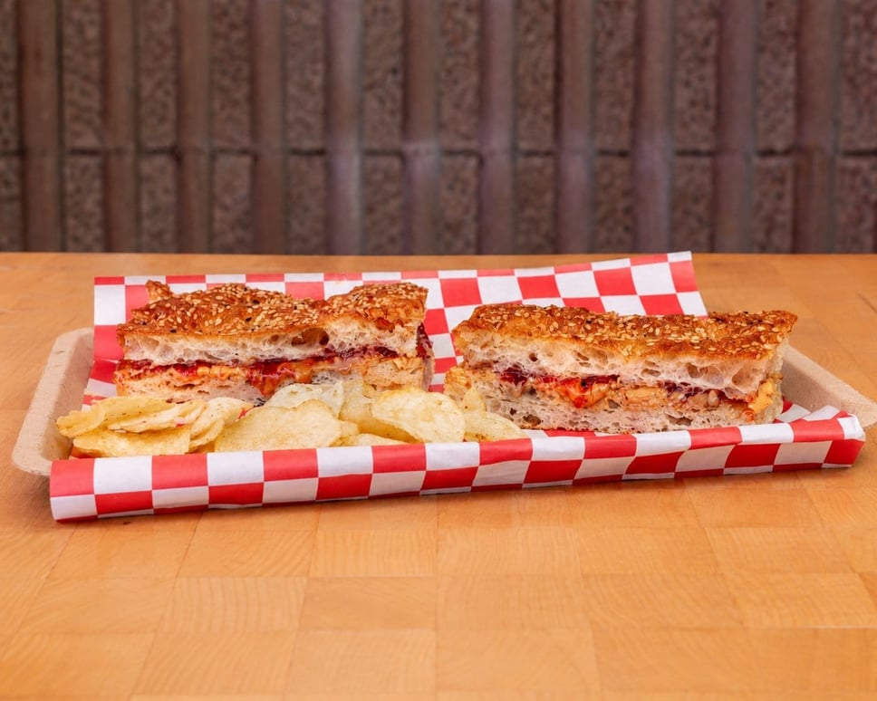 Crunchy peanut butter and strawberry jelly with candied Nueske's bacon, pressed on the plancha · 📸 PHOTO VIA FRANK N' FRANKS
