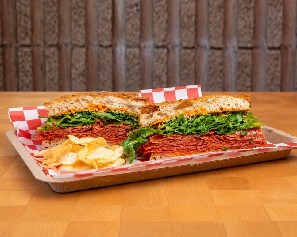 The Spicy Italian: spicy salami, 'nduja stracciatella, arugula and shaved Parmesan · 📸 PHOTO VIA FRANK N' FRANKS