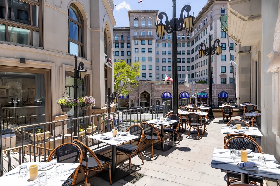 Sunlit outdoor terrace at Vicky on Rodeo with Parisian bistro chairs overlooking Rodeo Drive.